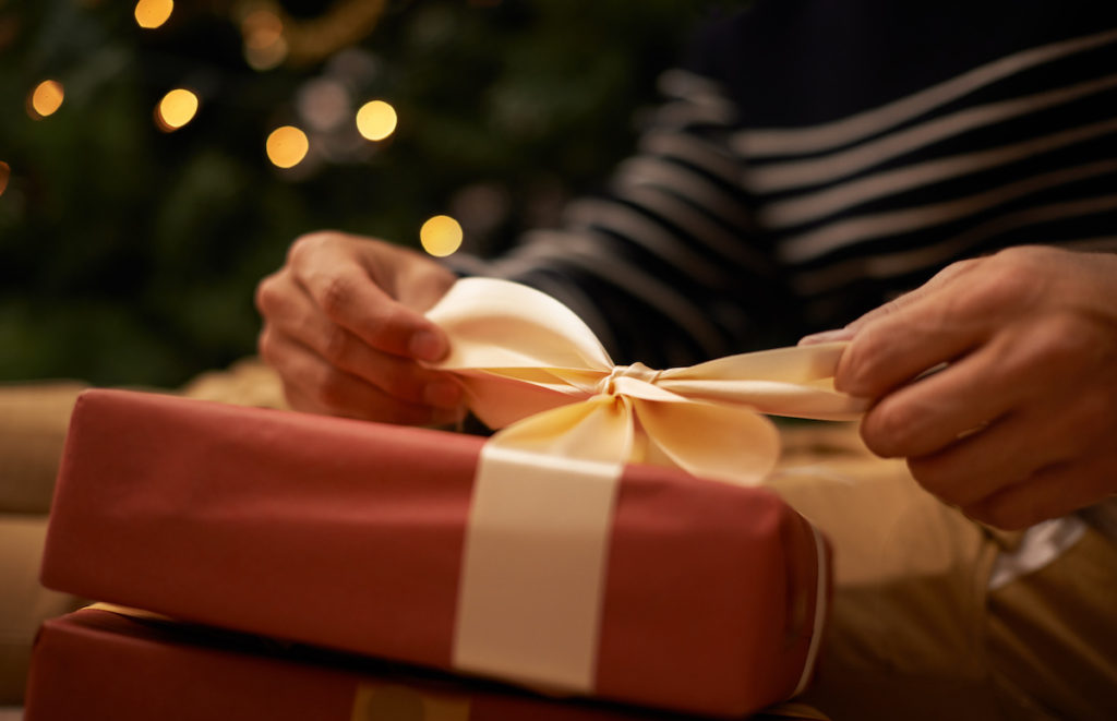 man opening gift staying sober during holidays