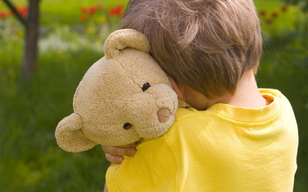 Boy holding onto teddy bear