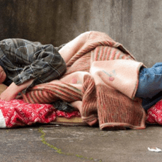 Homeless person lying in blankets