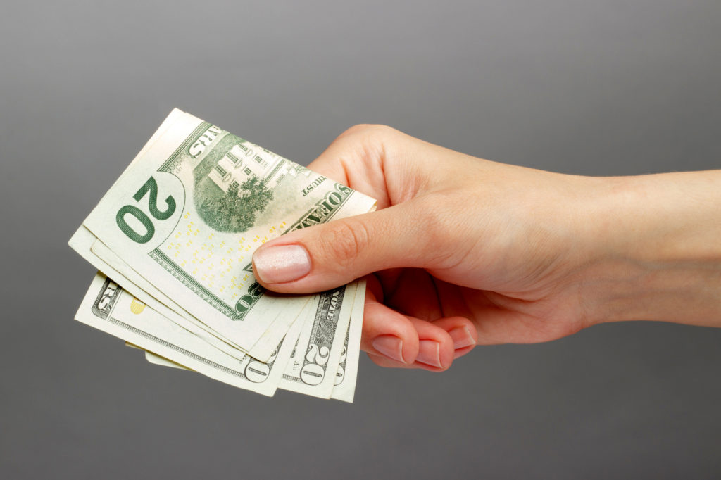 Hand holding $20 bills