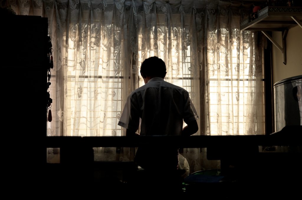The back of a man sitting at table
