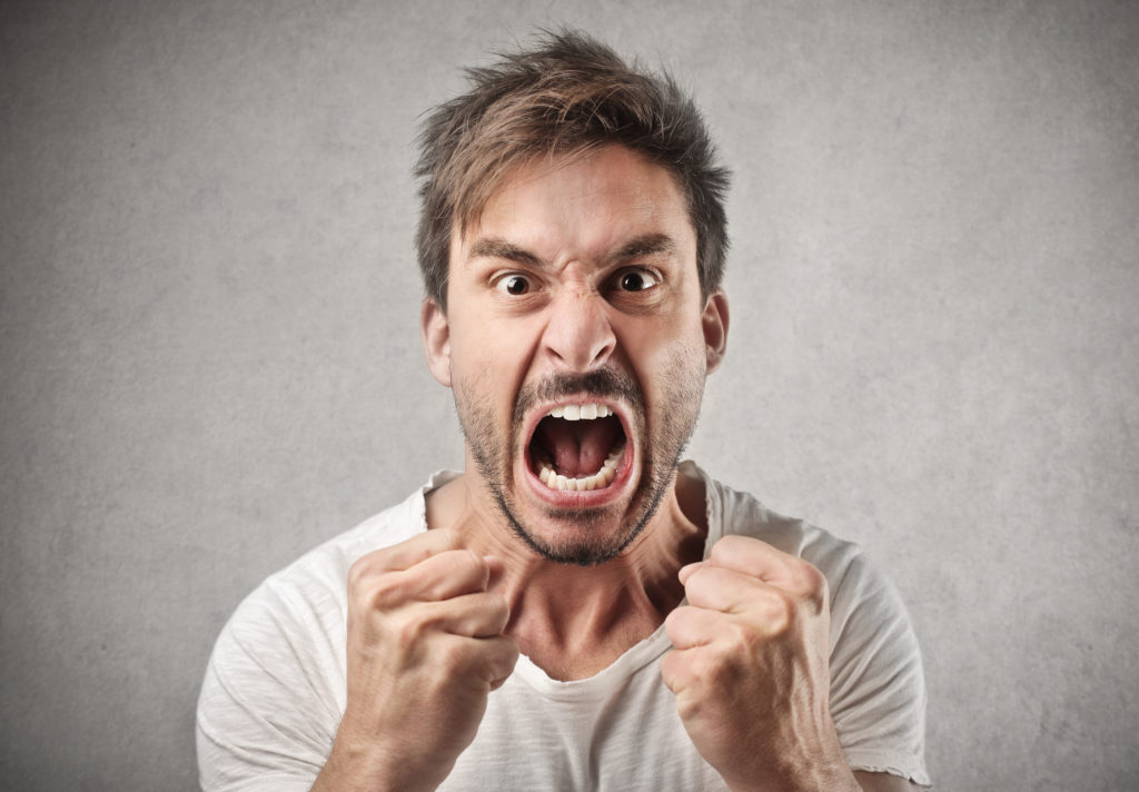 Angry man screaming with clenched fists