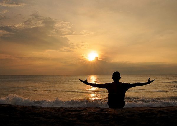 Man with arms open at the ocean