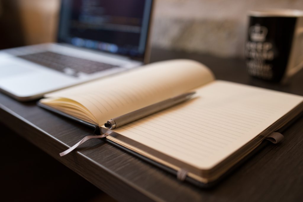 Open notebook next to laptop