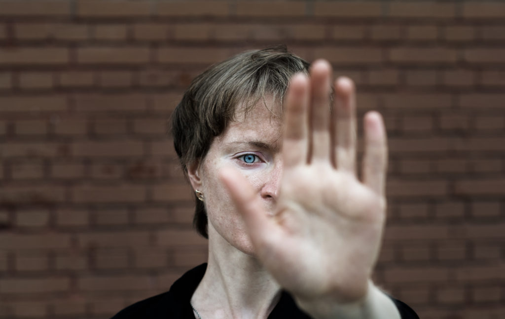 Woman holding her hand up in front of her face