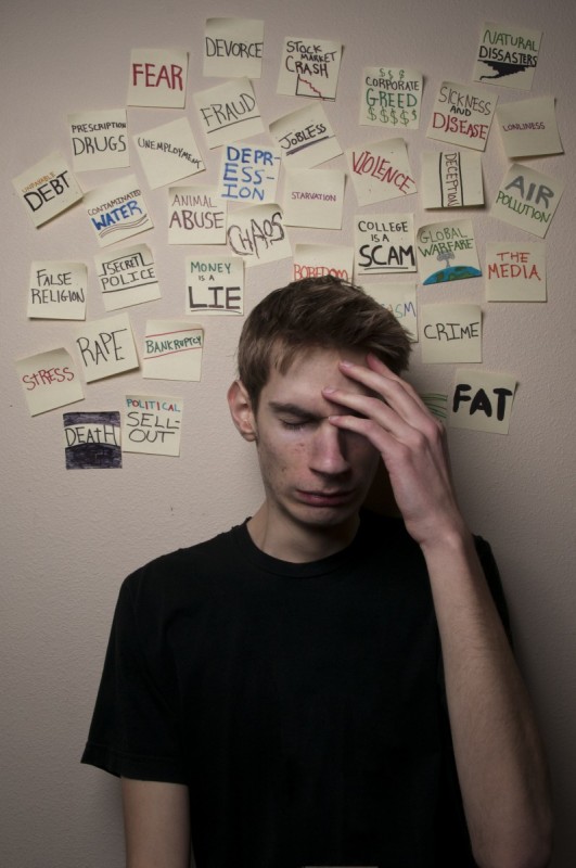 Young man with post it notes with inner thoughts written on them