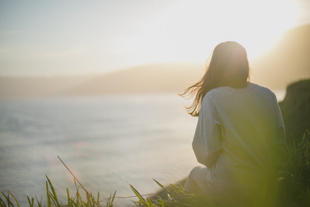 The back of a woman staring out at the ocean