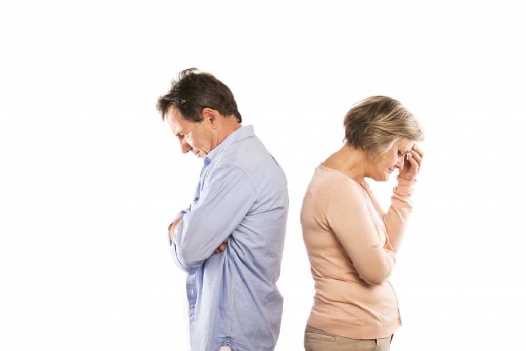 Upset man and woman facing away from each other with heads down