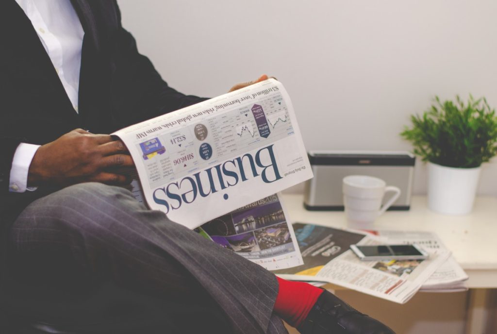 Man in suit reading the Business section of the newspaper