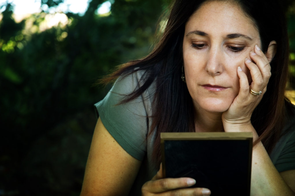 Woman looking longingly at picture frame