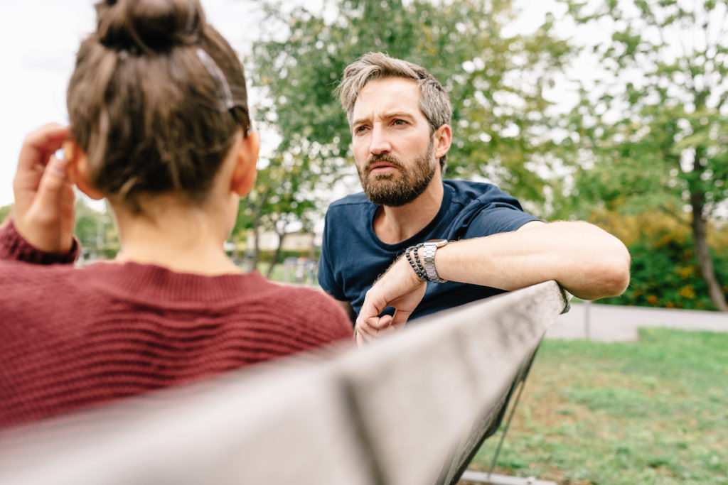 Father talking to daughter on bench