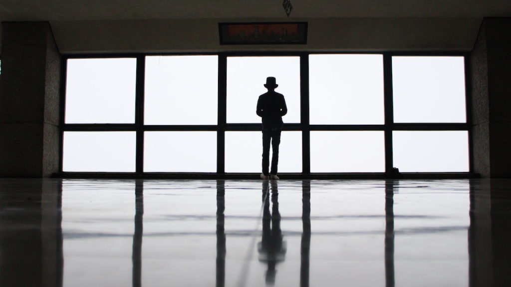 Man staring out of a floor to ceiling window