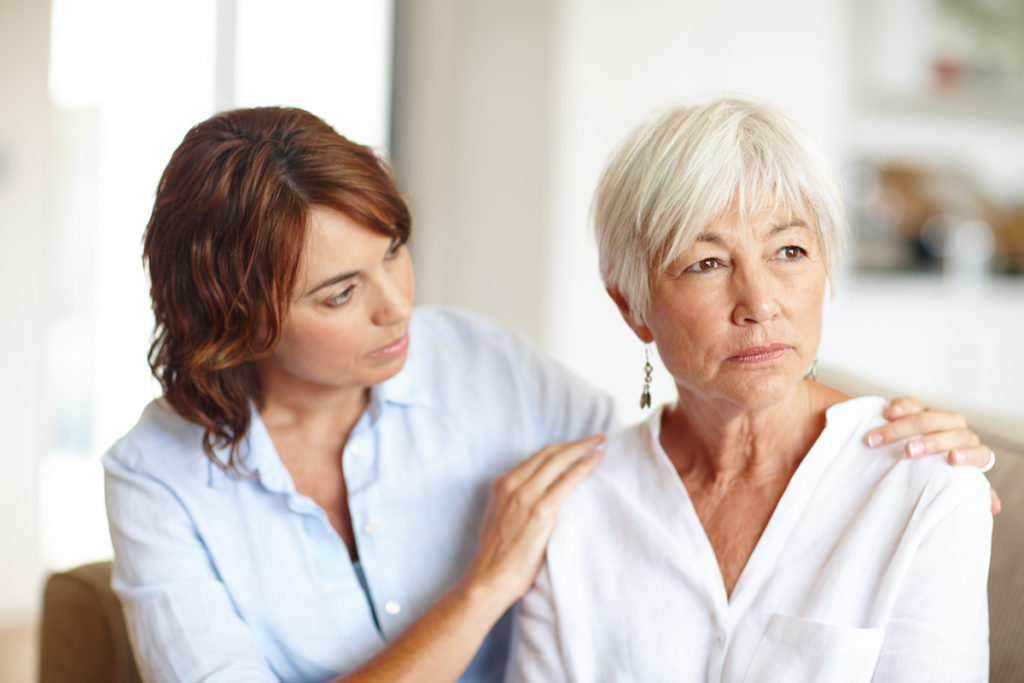 Woman with hands on her mother's shoulders