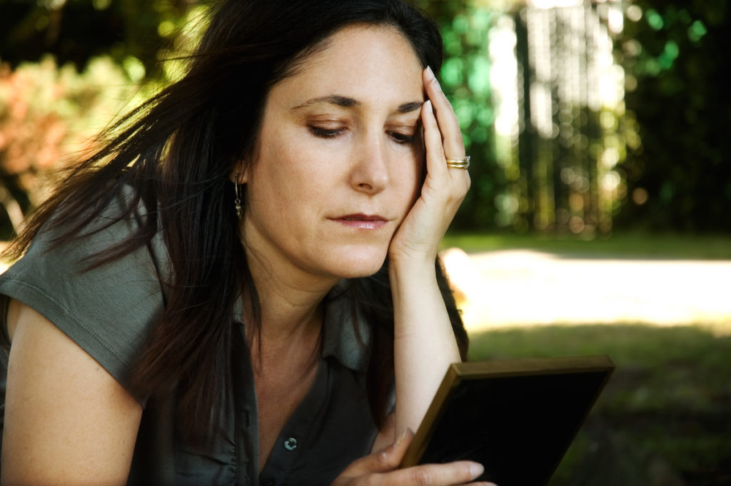 Sad woman looking at picture frame