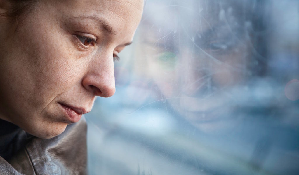 Sad woman looking out window