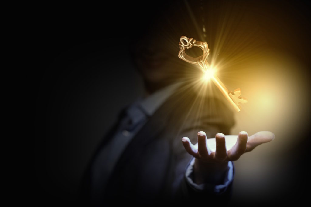 Man with palm open and glowing gold floating key