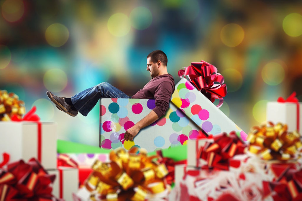 Man sitting in oversized Christmas present box