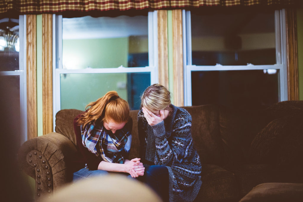 Two women crying on couch