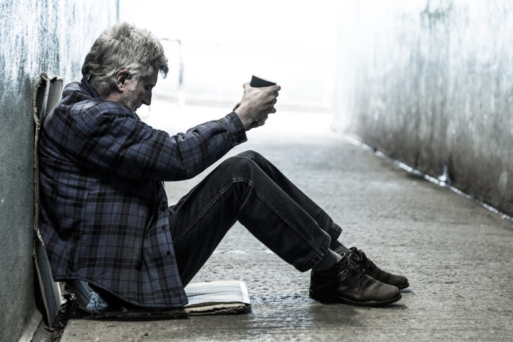 Homeless man sitting in alley