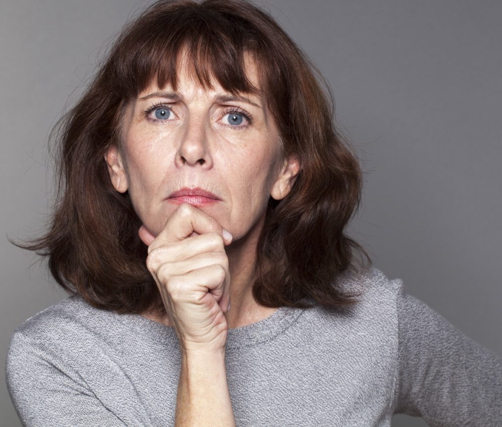 Serious woman with hand on chin