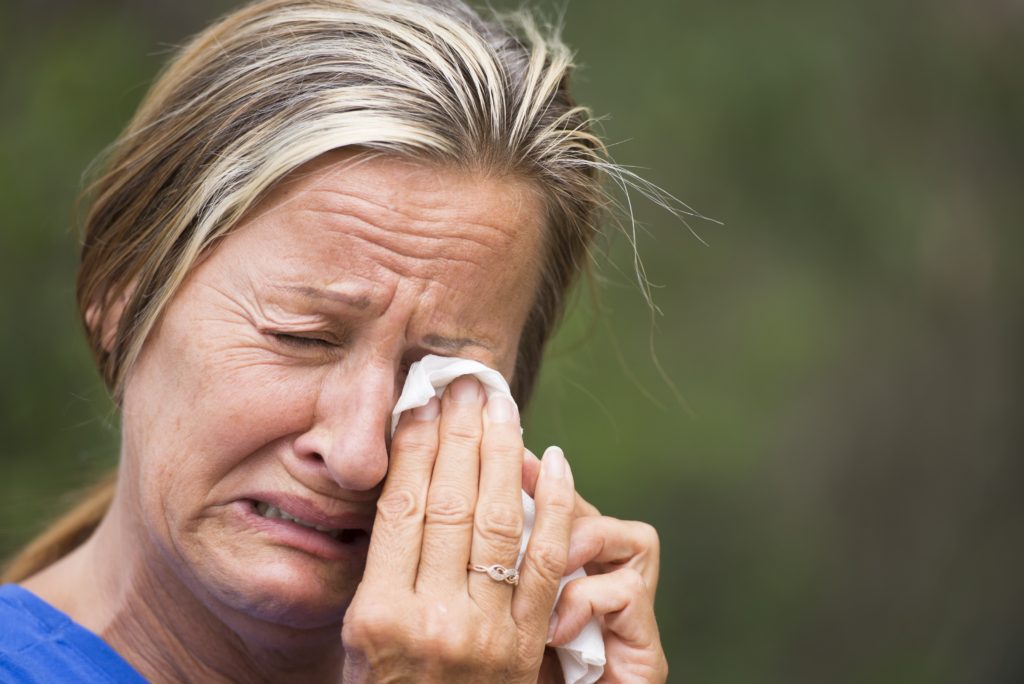 Woman crying into tissue