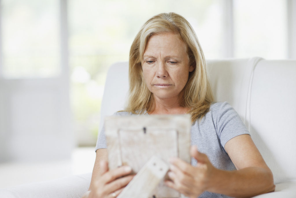 Sad woman looking at picture frame