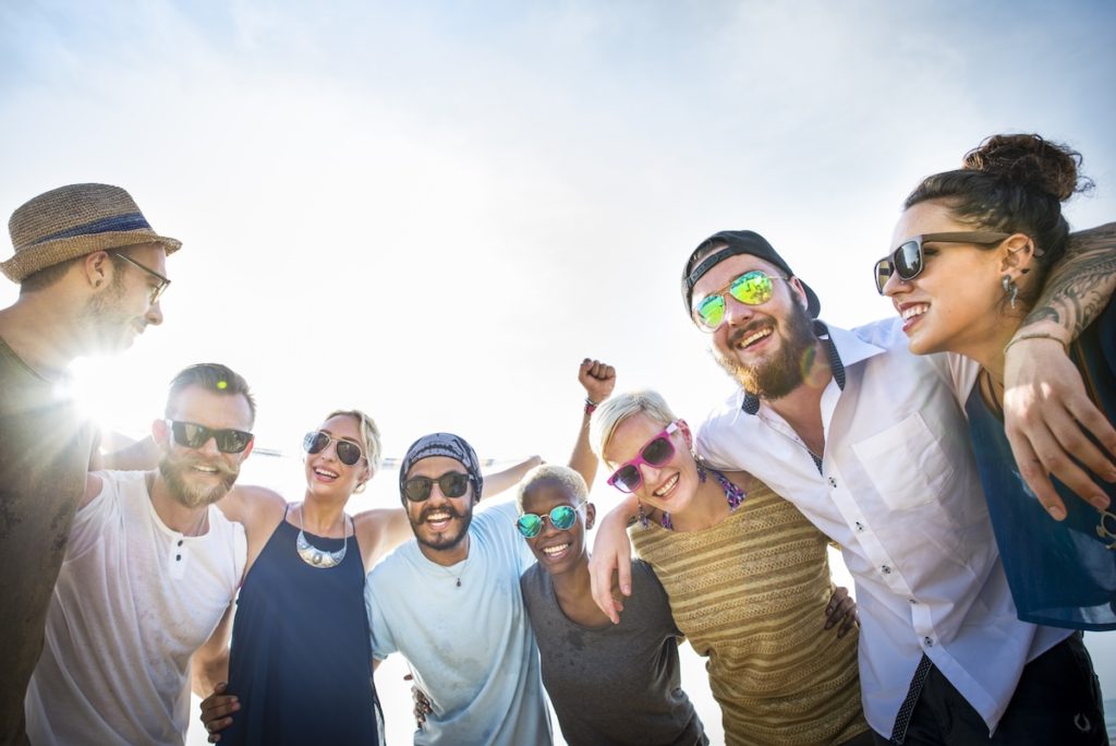 Group of friends with arms around each other smiling
