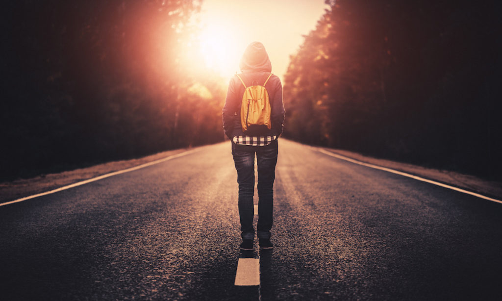 The back of a person walking down road