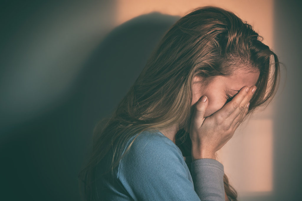 Woman crying into her hands