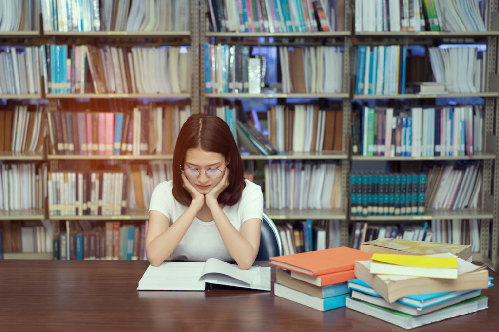 Woman sitting in library reading a book
