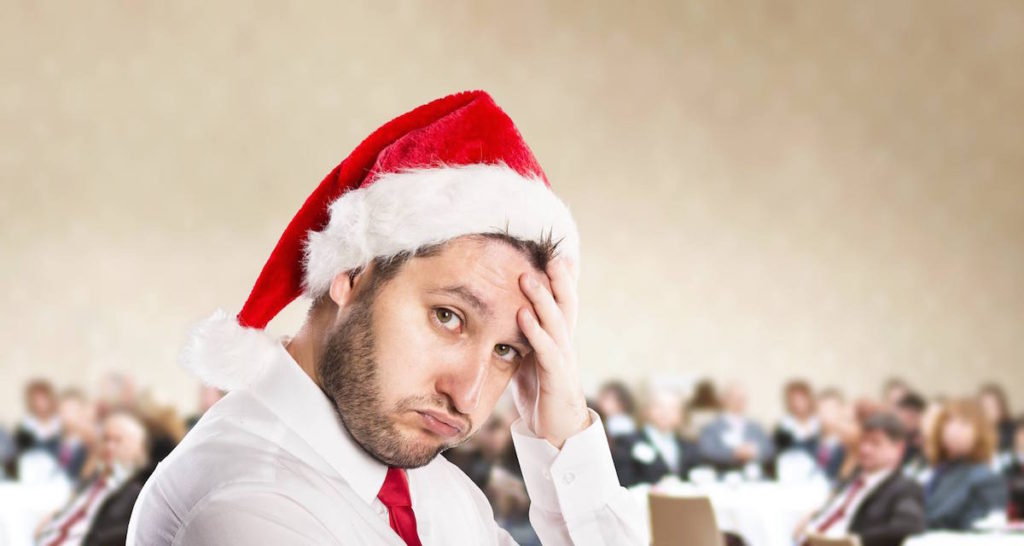 Man in a suit and Santa hat looking upset
