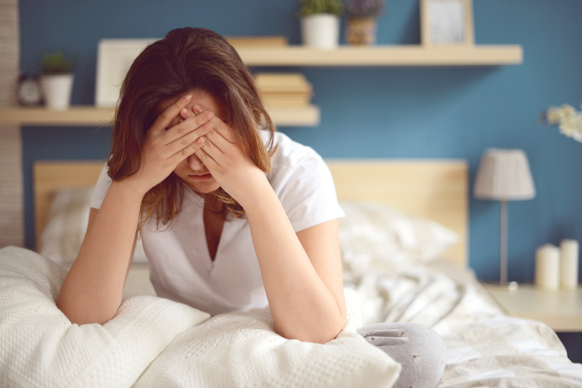 Woman sitting up in bed looking upset