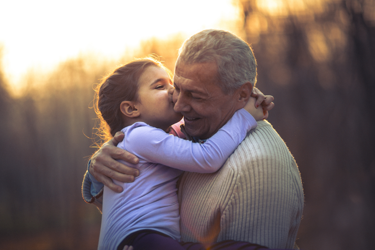 Granddaughter kissing grandfather on cheek