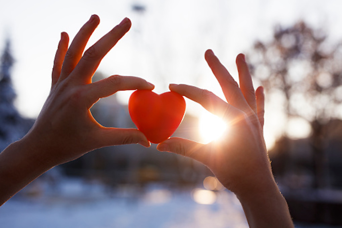 Two hands holding red heart