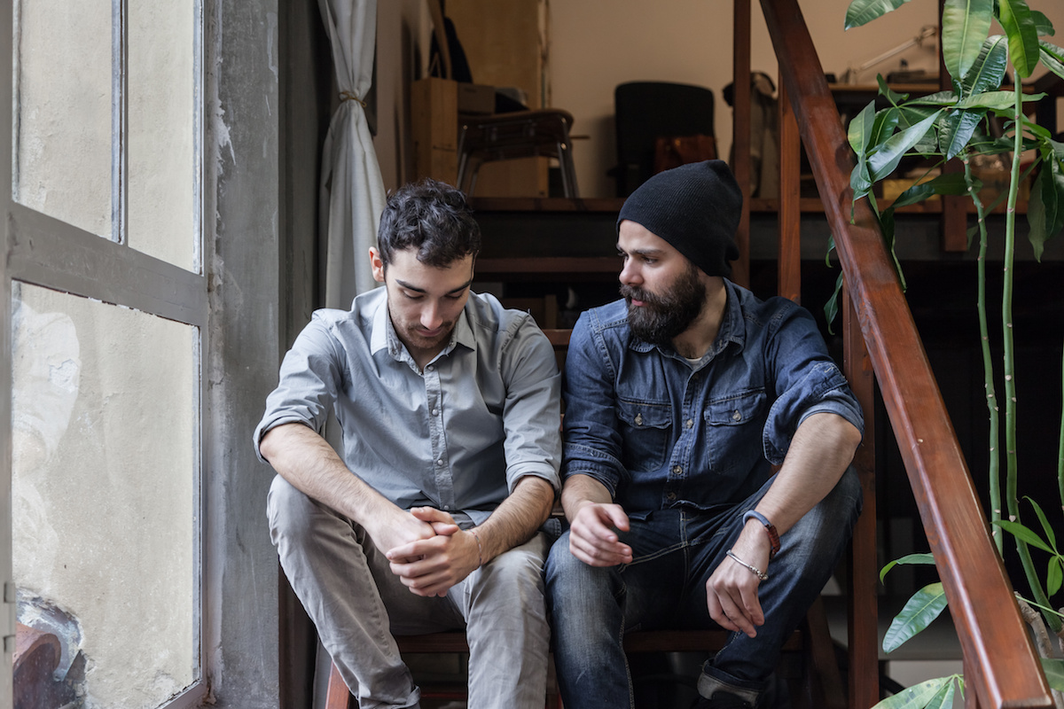 Two men sitting on stairs talking