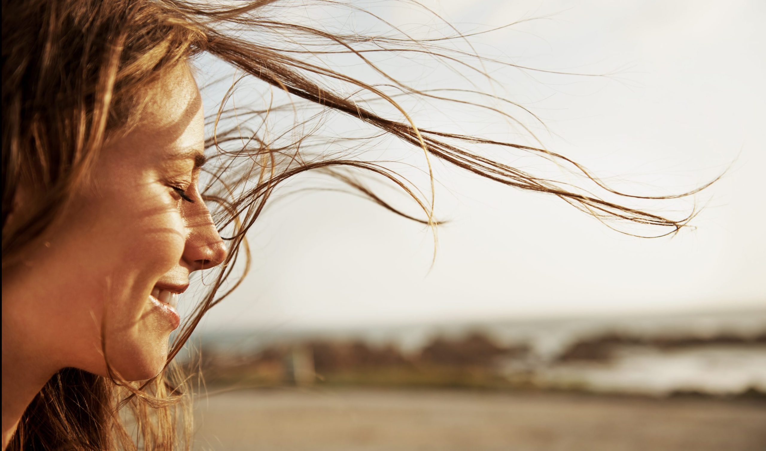 Woman smiling with hair blowing in the wind