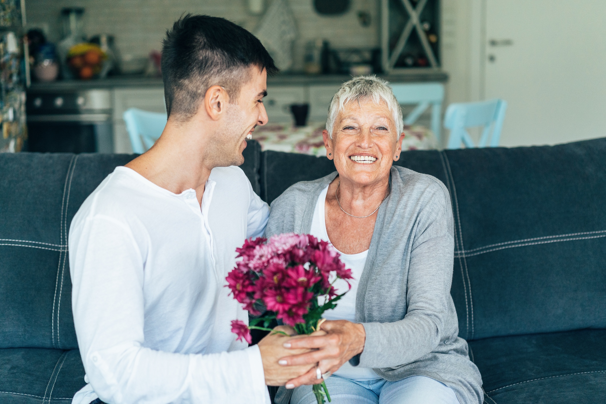Son giving flowers to Mom