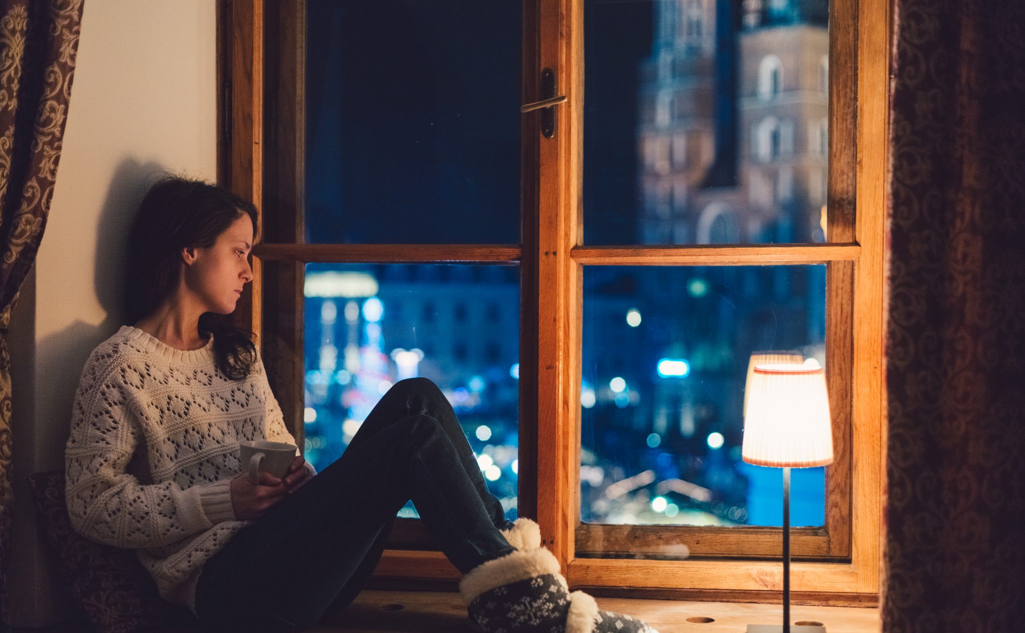 Woman at window with holiday anxiety