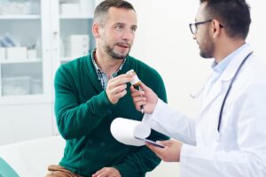 a man talks to his doctor about the benefits of medication assisted treatment or mat for recovery
