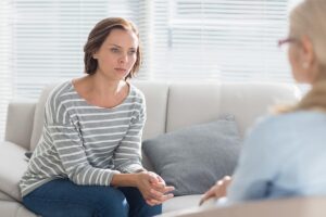 a woman discusses the connection between bipolar disorder and alcohol addiction with a therapist