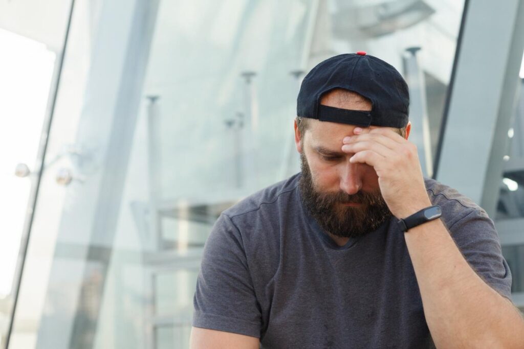 a man holds his head as he considers signs of lorazepam withdrawal symptoms
