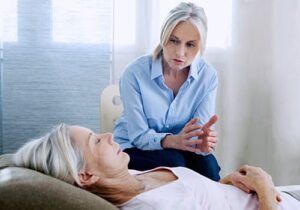 a woman undergoes hypnotherapy treatment at a hypnotherapy program under the care of an older woman