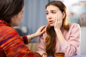 Worried woman talking to friend, worried that her loved one has relapsed