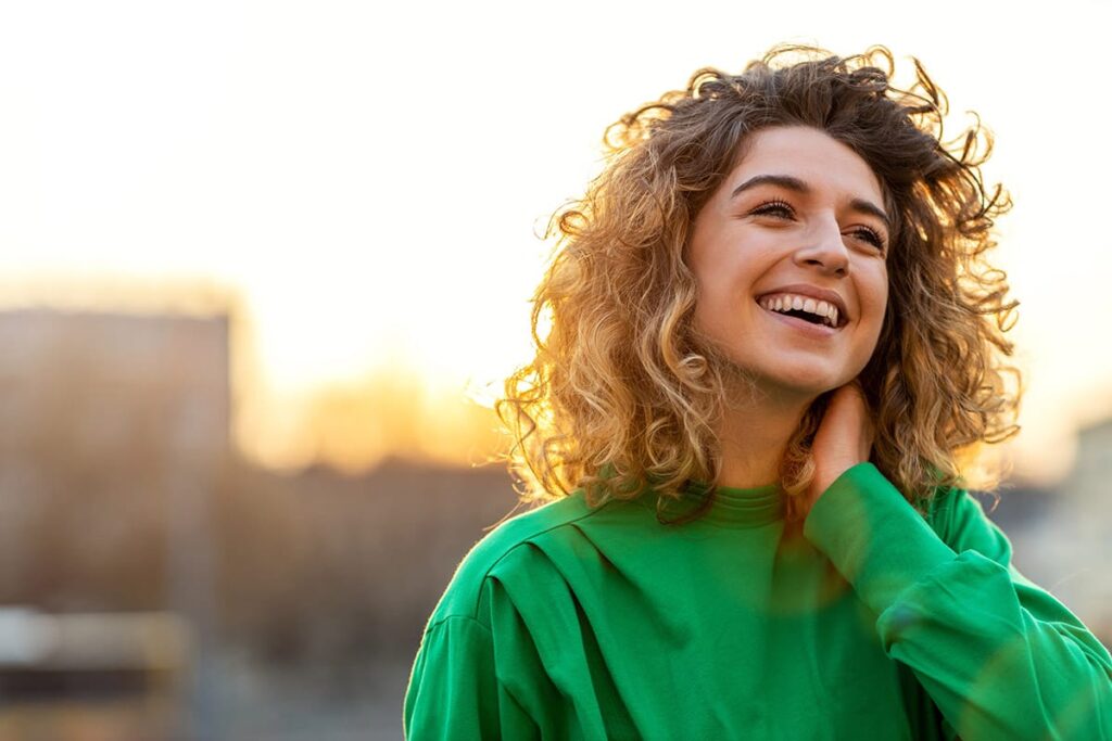 Woman smiles and breathes fresh air after learning what happens after detox