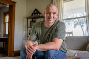 Veteran in green shirt ponders if the VA benefits will cover addiction treatment for him